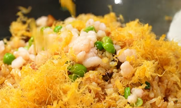 Close-up of Yangzhou fried rice with shrimp, green peas, and golden egg threads