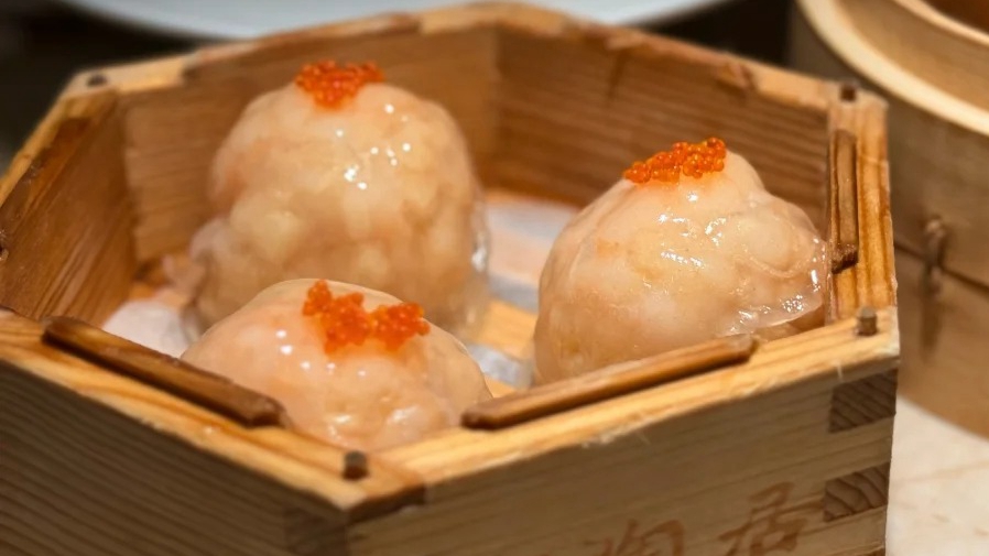 Shrimp dumplings topped with roe in a bamboo steamer at Tao Tao Ju