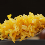 Spoonful of golden egg fried rice with separate rice grains