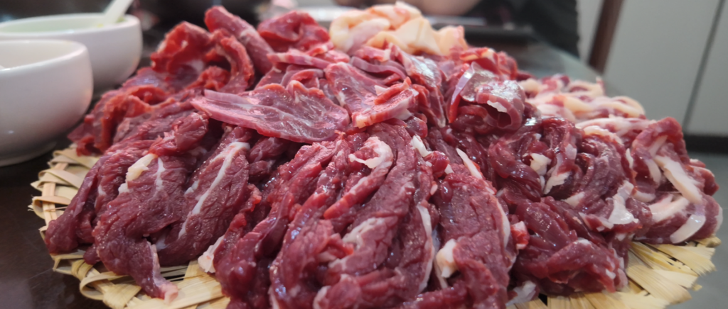 Raw sliced beef on a bamboo tray for beef hotpot
